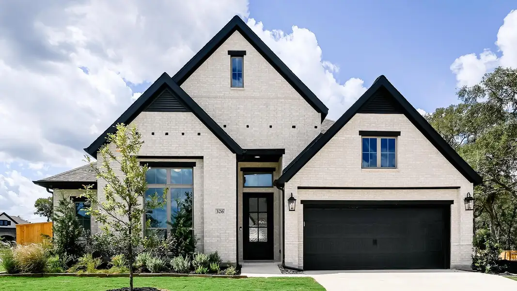 View of front of property with brick siding, driveway, and a front yard