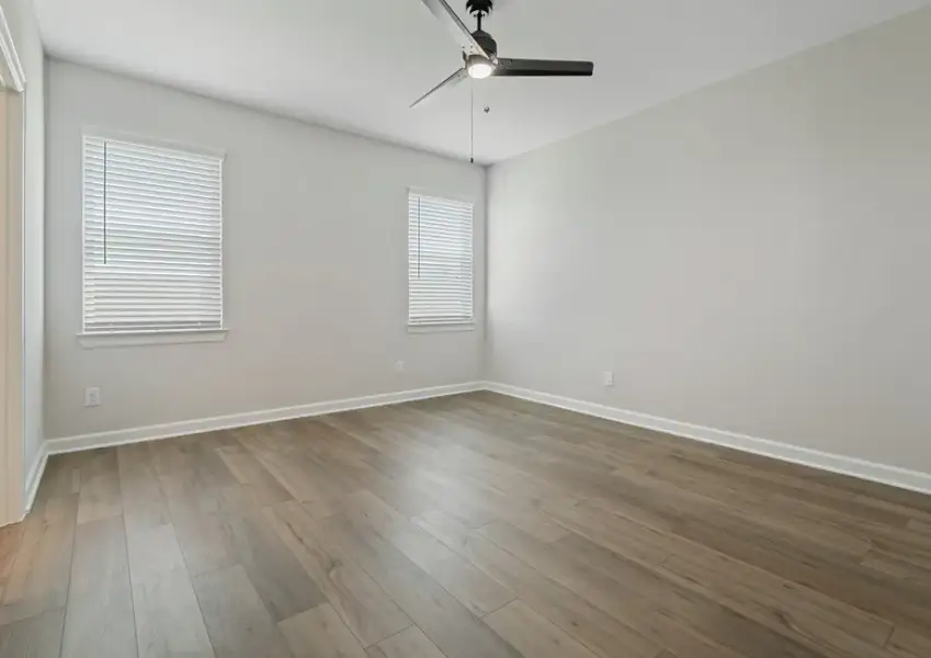 Master bedroom with two windows and ceiling fan light fixture