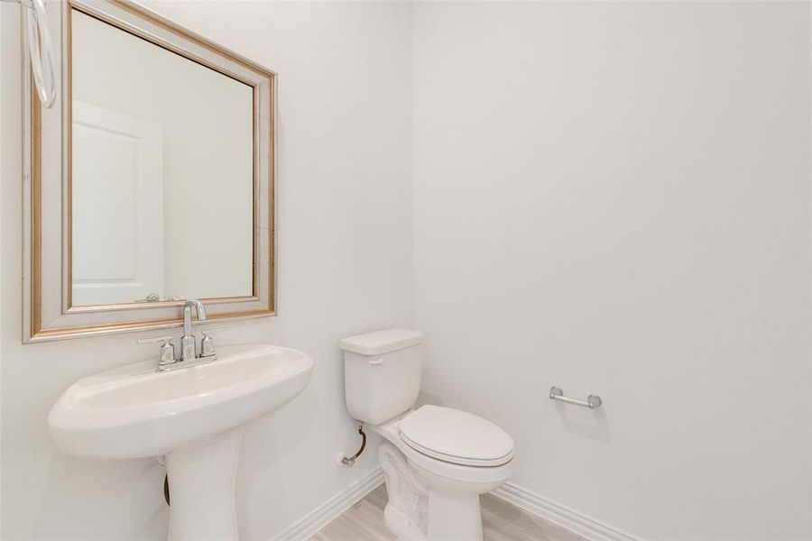 Bathroom with toilet, wood-type flooring, and sink