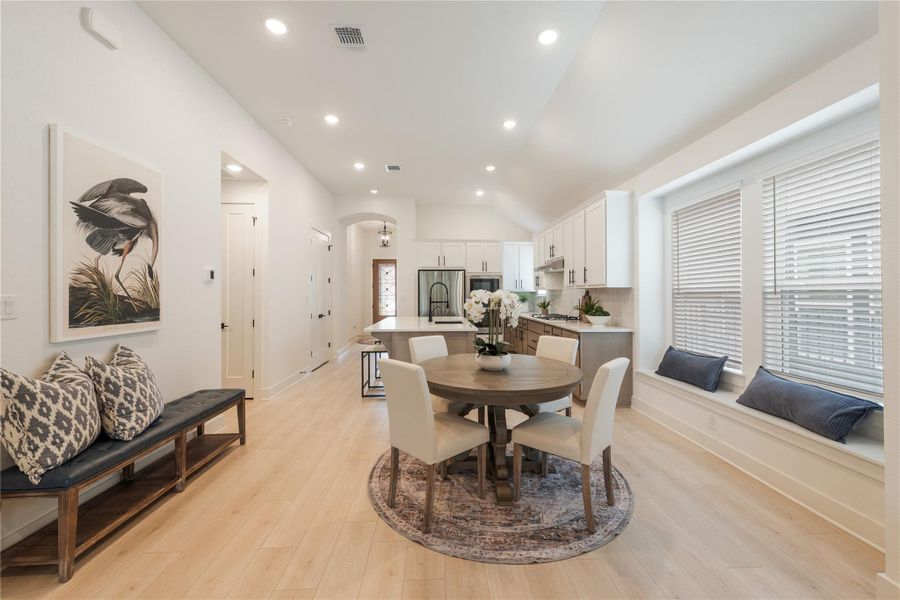 A well-appointed kitchen boasts sleek appliances and an adjacent dining area with a charming window seat. A well-appointed kitchen boasts sleek appliances and an adjacent dining area with a charming window seat.