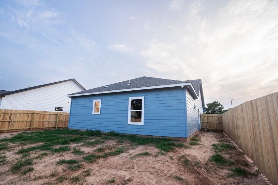 Rear view of house with a fenced backyard and roof with shingles Rear view of house with a fenced backyard and roof with shingles