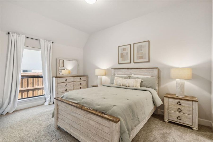 Carpeted bedroom with lofted ceiling