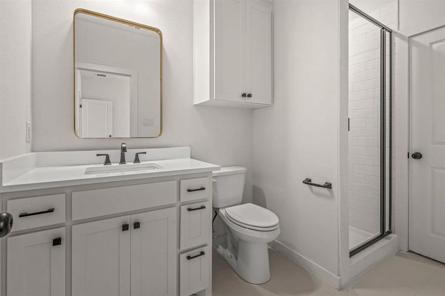 Full bath featuring toilet, a stall shower, and vanity
