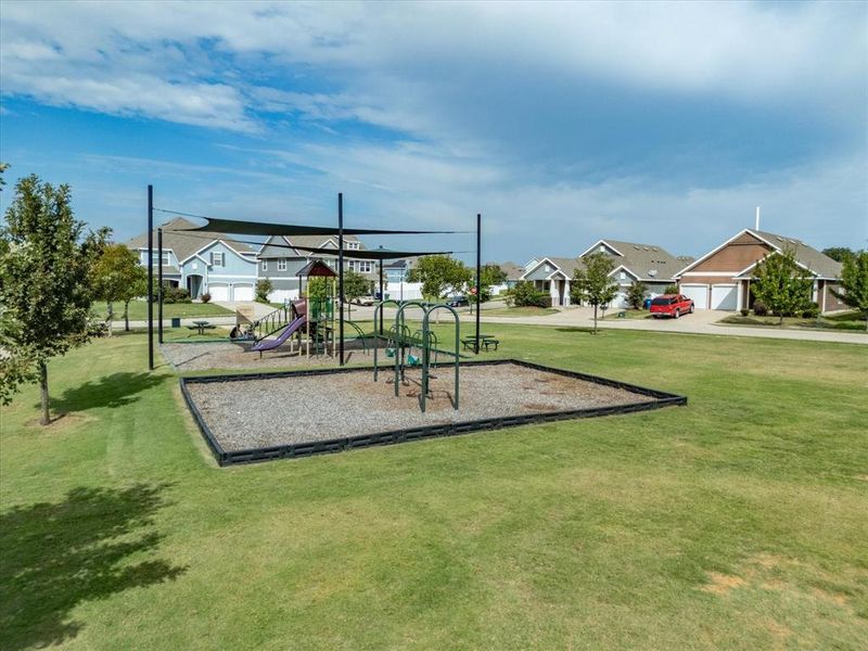 Community play area featuring a yard and a residential view Community play area featuring a yard and a residential view