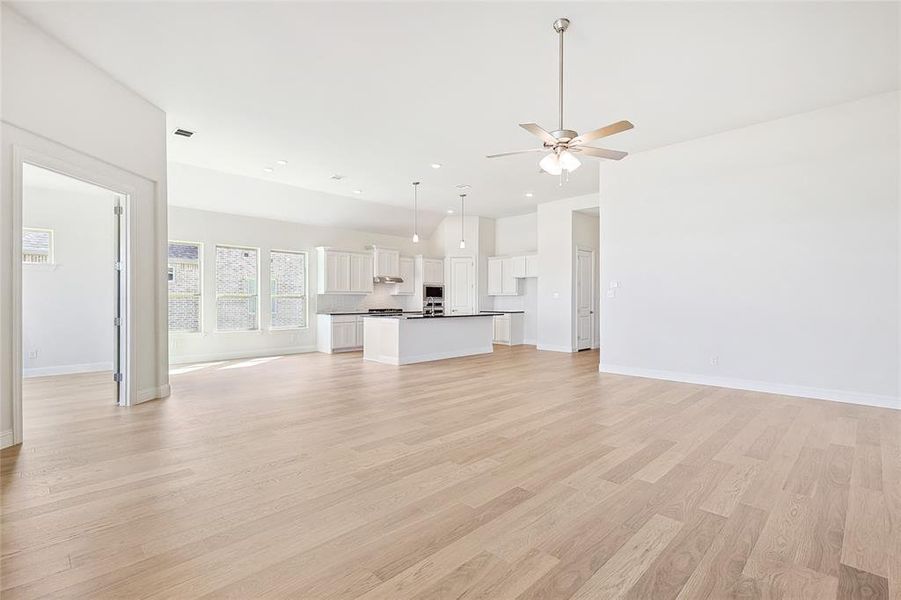 Unfurnished living room with ceiling fan and light hardwood / wood-style flooring