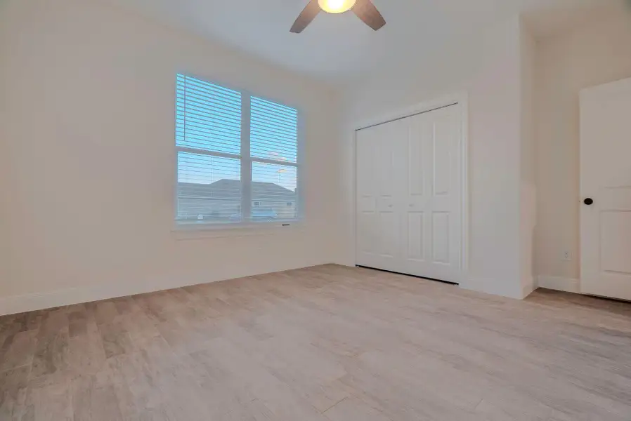 Unfurnished bedroom with light wood finished floors, a ceiling fan, and a closet Unfurnished bedroom with light wood finished floors, a ceiling fan, and a closet
