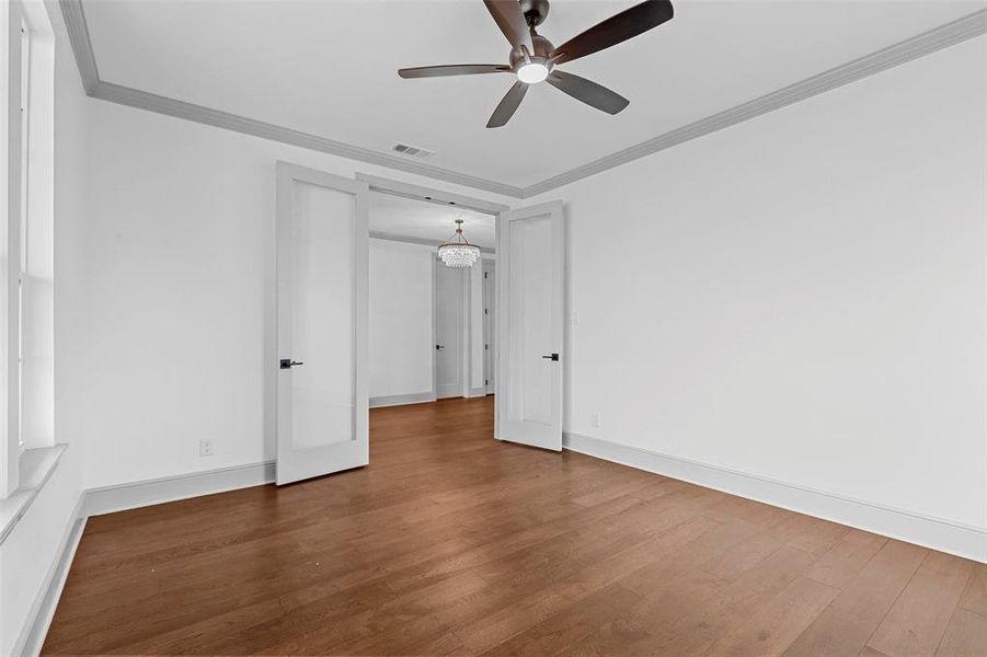 Spare room with ornamental molding, hardwood / wood-style floors, and ceiling fan