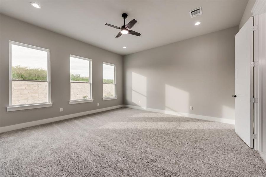 Carpeted empty room with ceiling fan