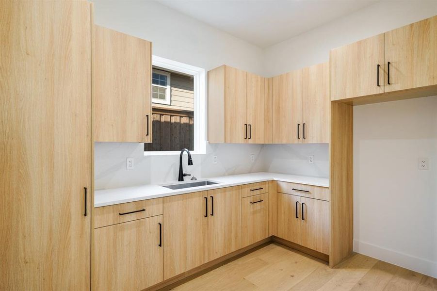 Kitchen featuring sink, light brown cabinets, and light hardwood / wood-style flooring