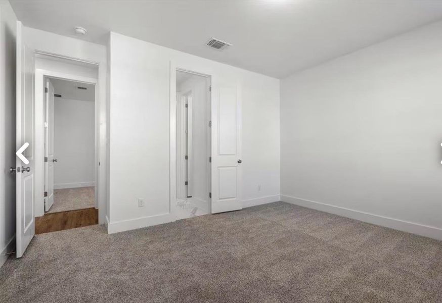 Unfurnished bedroom with carpet floors and baseboards