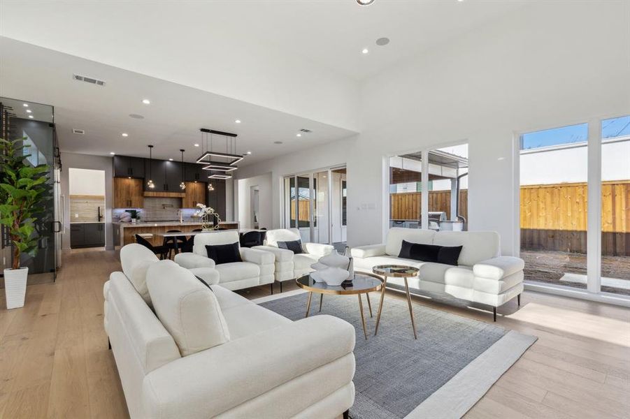 Living room with a high ceiling and light wood-type flooring