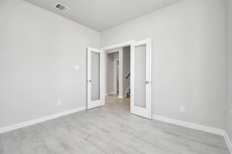 Another view of home office equipped with French doors. Sample photo of completed home. Actual colors and selections may vary.