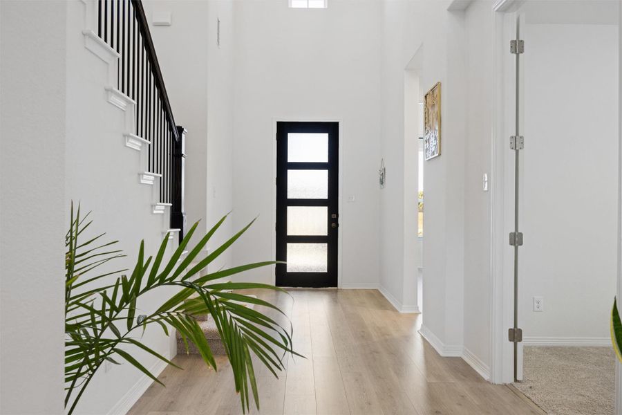 Foyer entrance with light wood-type flooring and a high ceiling Foyer entrance with light wood-type flooring and a high ceiling
