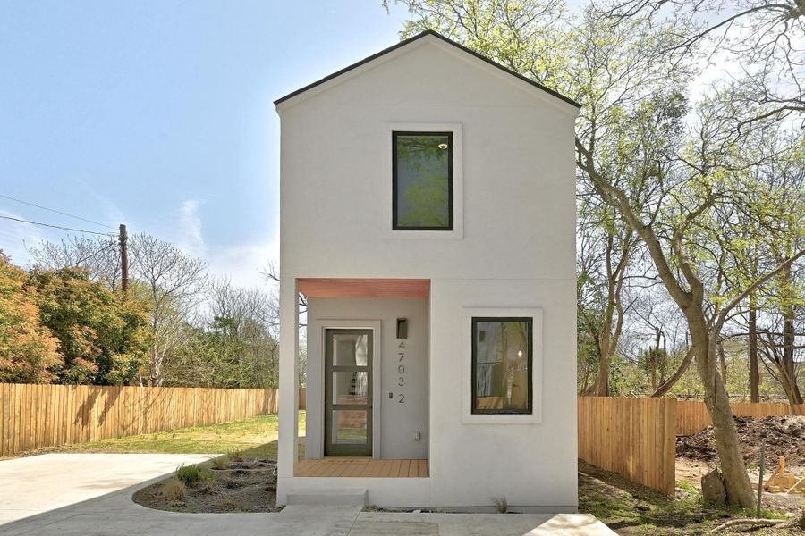 View of front of property with stucco siding and fence