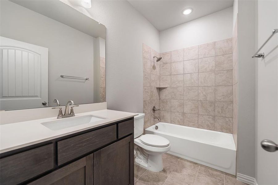 Bathroom with bathtub / shower combination, vanity, and light tile patterned flooring Bathroom with bathtub / shower combination, vanity, and light tile patterned flooring