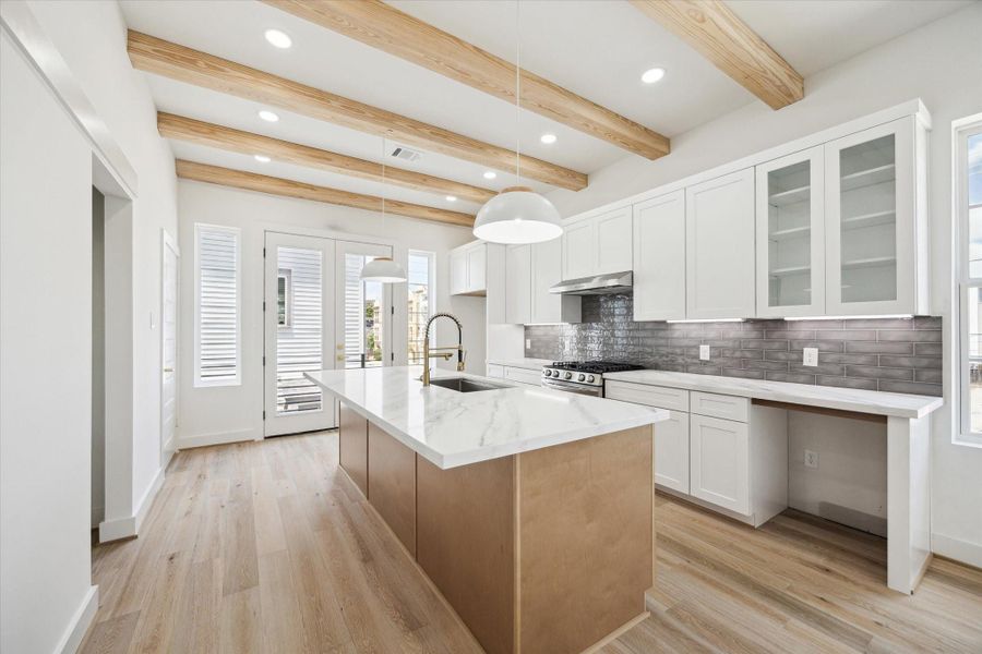 An entertainer's kitchen! Oversized Quartz island with seating up to five people with a warm oak natural wood base. Knobs and handles to be chosen by buyer and installed by builder. Wine fridge included and to be installed. Buyer to select hardware. Your chance to still add personal touches to customize your new home!