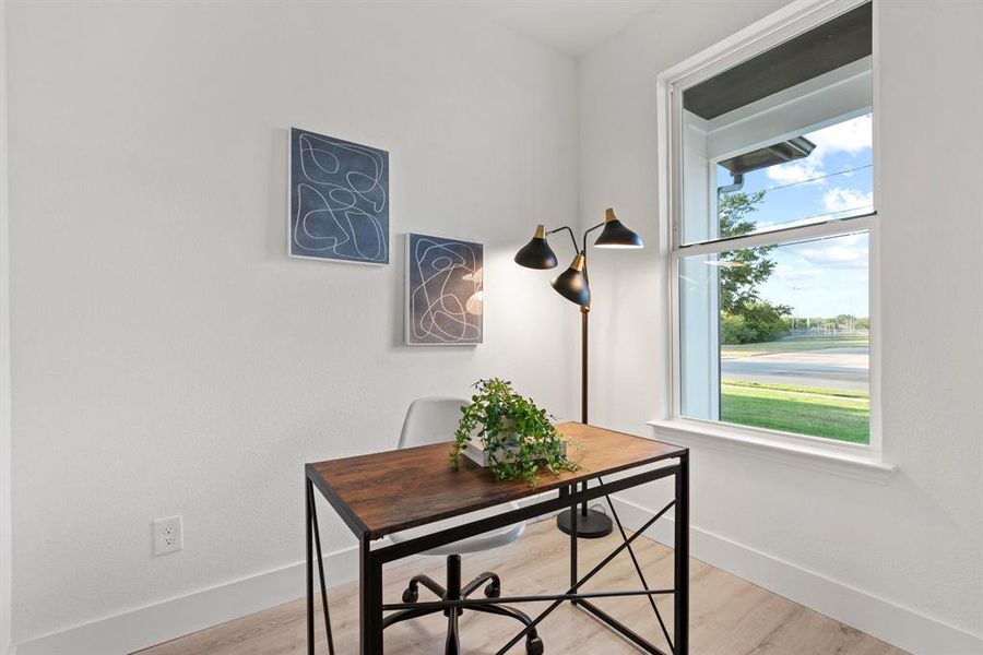 Office space with light hardwood / wood-style flooring