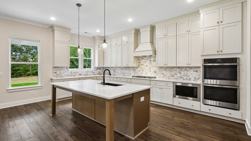 Kitchen with quartz countertops, tile backsplash, and pendant lighting Kitchen with quartz countertops, tile backsplash, and pendant lighting