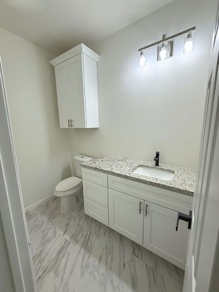 Bathroom featuring vanity and light marble finish floors