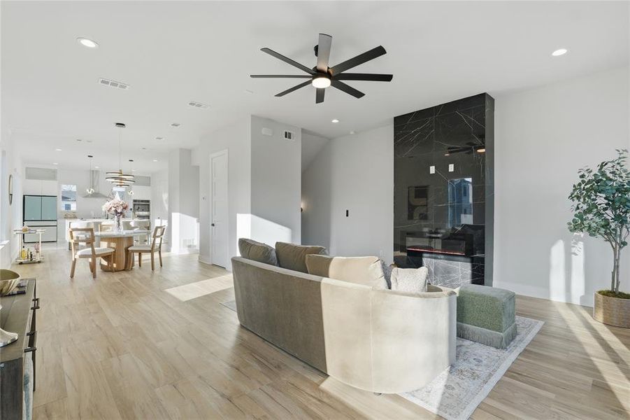 Living room with light wood-style floors, a ceiling fan, and recessed lighting Living room with light wood-style floors, a ceiling fan, and recessed lighting