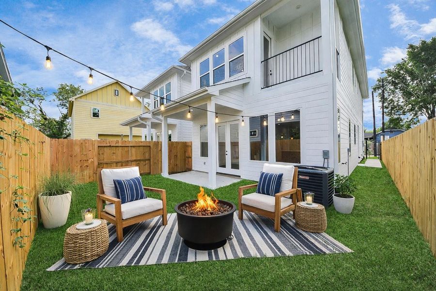 Private fenced backyard designed for entertaining, featuring a cozy seating area and inviting outdoor ambiance. Perfect for gatherings, relaxing evenings, or enjoying your own outdoor retreat.