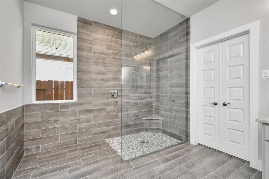 Enjoy a massive walk-in shower with tile surround. Sample photo of completed home with similar plan. As built color and selections will vary.