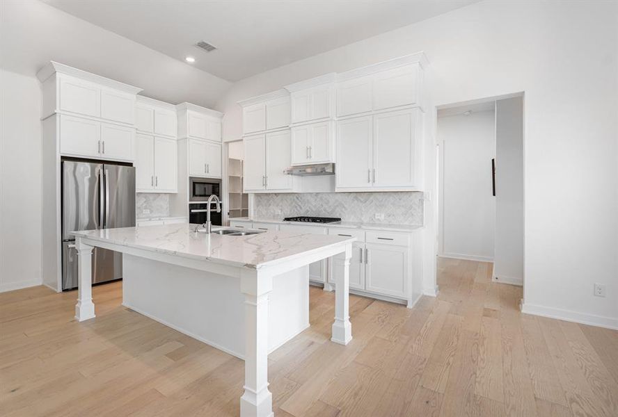Kitchen featuring decorative backsplash, white cabinets, appliances with stainless steel finishes, and recessed lighting Kitchen featuring decorative backsplash, white cabinets, appliances with stainless steel finishes, and recessed lighting