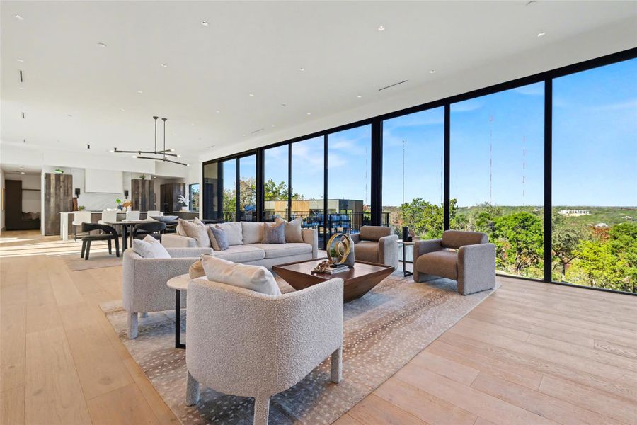 Living room featuring floor to ceiling windows and light wood-style flooring