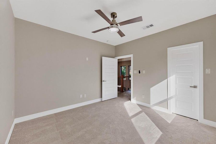 Unfurnished bedroom featuring light colored carpet and a ceiling fan