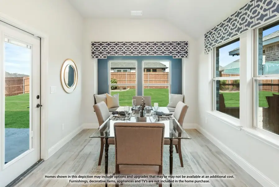 Bright dining room with glass table, vaulted ceiling, large windows, and backyard views Bright dining room with glass table, vaulted ceiling, large windows, and backyard views