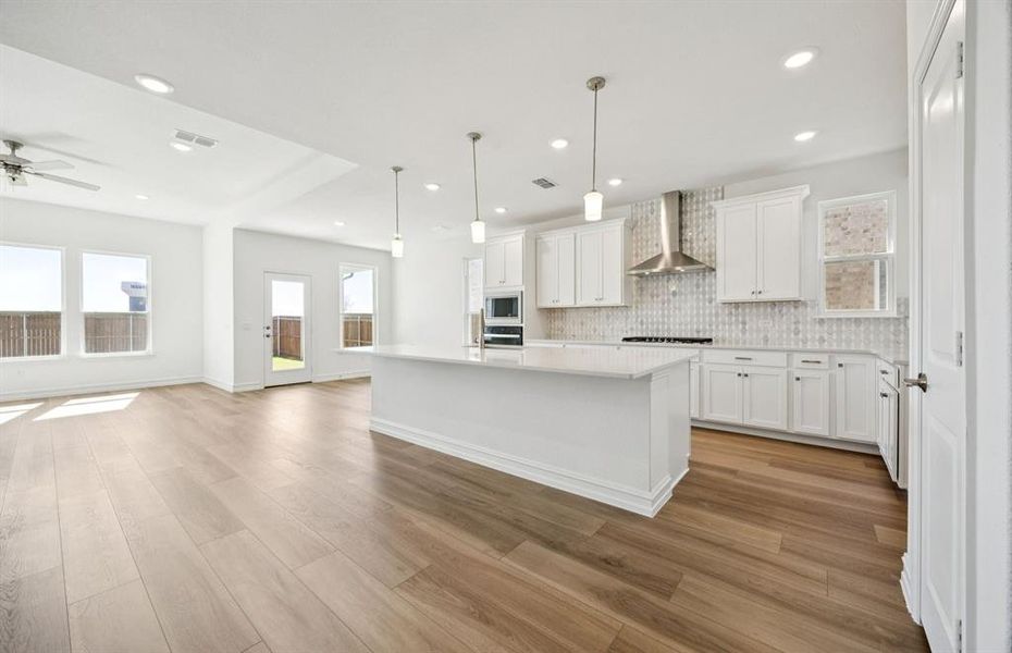 Large island overlooking gathering room and dining areas