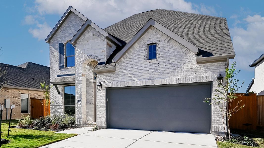 Front exterior of a new home in Crosswinds 50', Kyle, TX, highlighting curb appeal (Image 2). Front exterior of a new home in Crosswinds 50', Kyle, TX, highlighting curb appeal (Image 2).