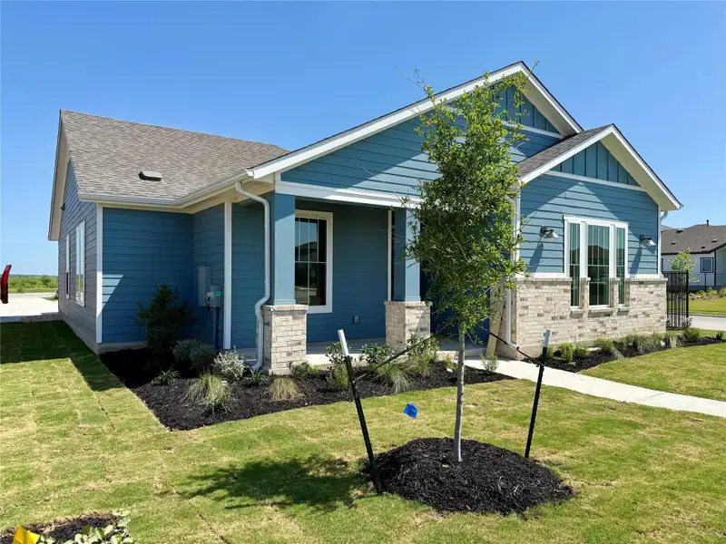 View of front facade with roof with shingles, board and batten siding, and a front lawn