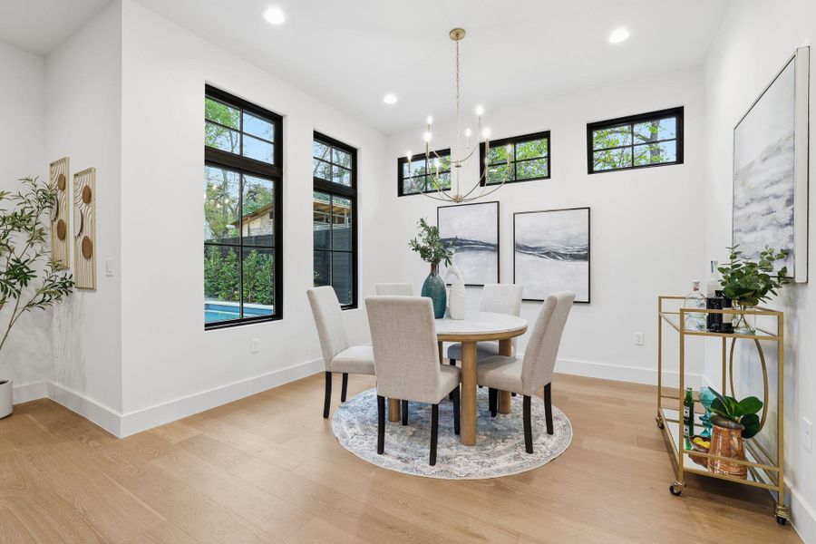 Dining room with light wood-type flooring, plenty of natural light, recessed lighting, and a chandelier