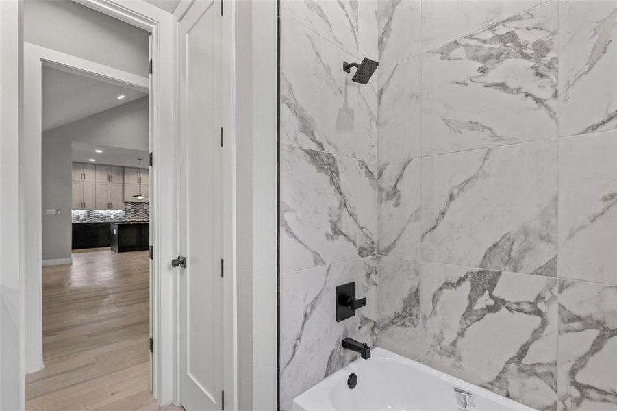 Bathroom featuring tiled shower / bath combo and hardwood / wood-style floors