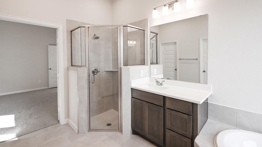 Full bath featuring a stall shower, vanity, a bath, and light tile patterned floors