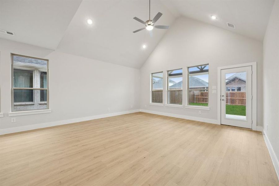 Unfurnished living room with ceiling fan, high vaulted ceiling, and light hardwood / wood-style flooring