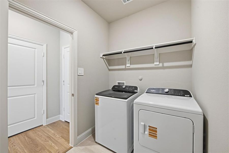 Laundry room featuring light wood-style flooring and separate washer and dryer