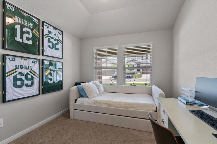 Bright room featuring two windows with blinds, a vaulted ceiling, neutral wall paint, and carpet flooring Bright room featuring two windows with blinds, a vaulted ceiling, neutral wall paint, and carpet flooring