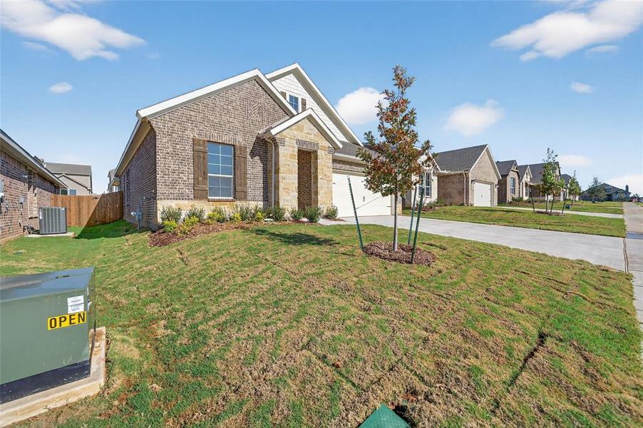 View of front of home featuring brick siding, concrete driveway, and a garage