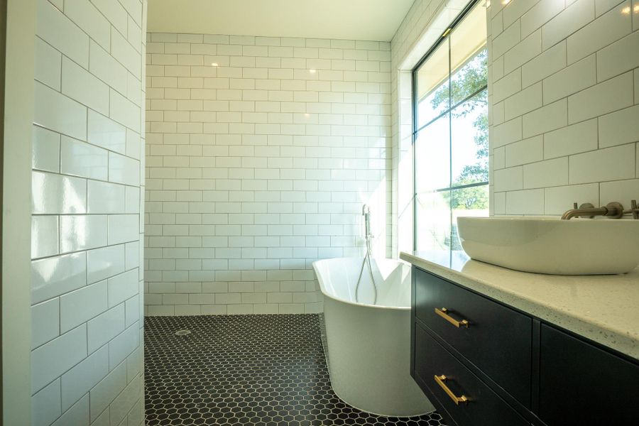 Bathroom with tile walls, vanity, a soaking tub, tile patterned flooring, and tiled shower