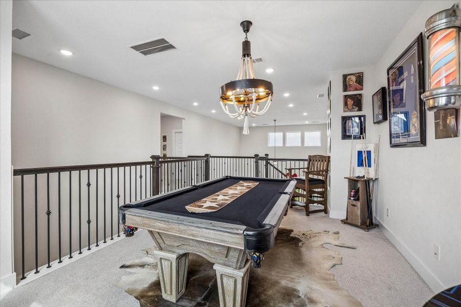 Upstairs, the spacious game room welcomes you with plenty of room for a pool table or additional lounge seating, all enhanced by large windows that bring in natural light.
