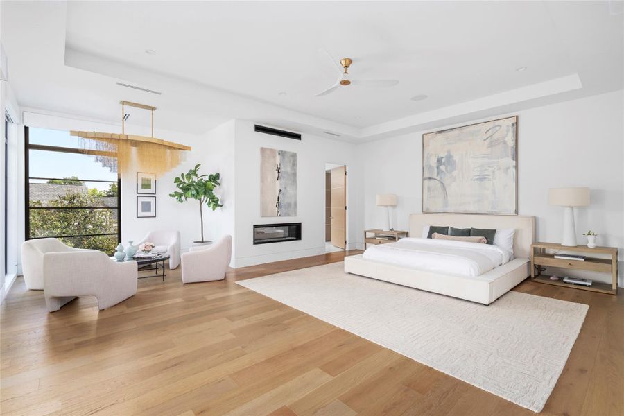 [Primary Suite] has linear gas fireplace with remote control. Wood floors, chandelier and windows overlooking backyard and pool.