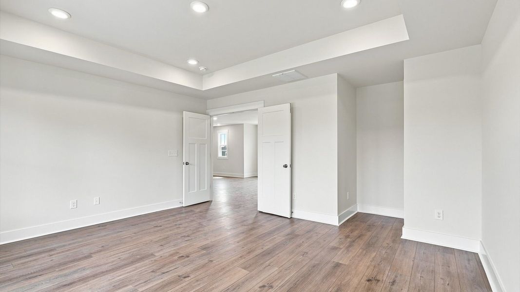 Accomplished primary retreat with eye-catching hardwood flooring in a desirable community