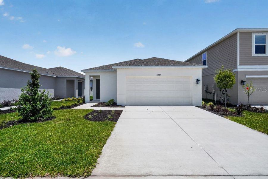 Front exterior of a new home in Firethorn, Parrish, FL, highlighting curb appeal (Image 15).