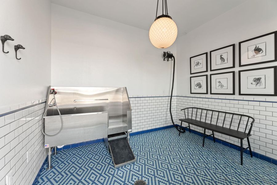 Misc room featuring wainscoting, tile walls, and pet washing station