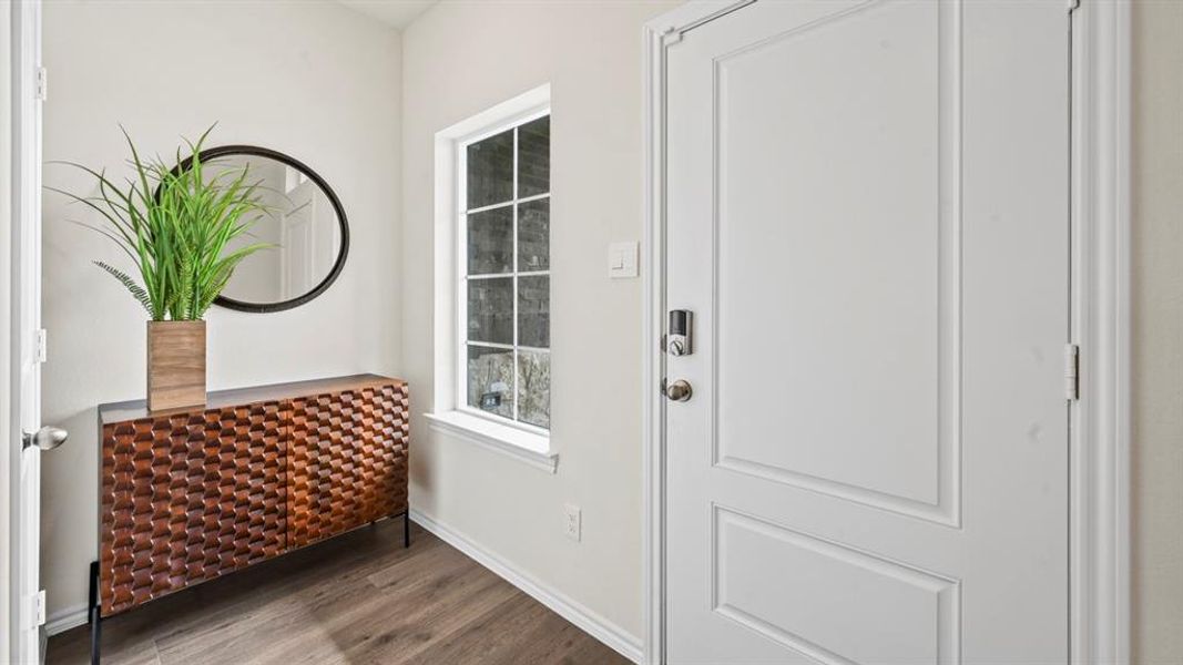 Doorway to outside with wood finished floors and baseboards