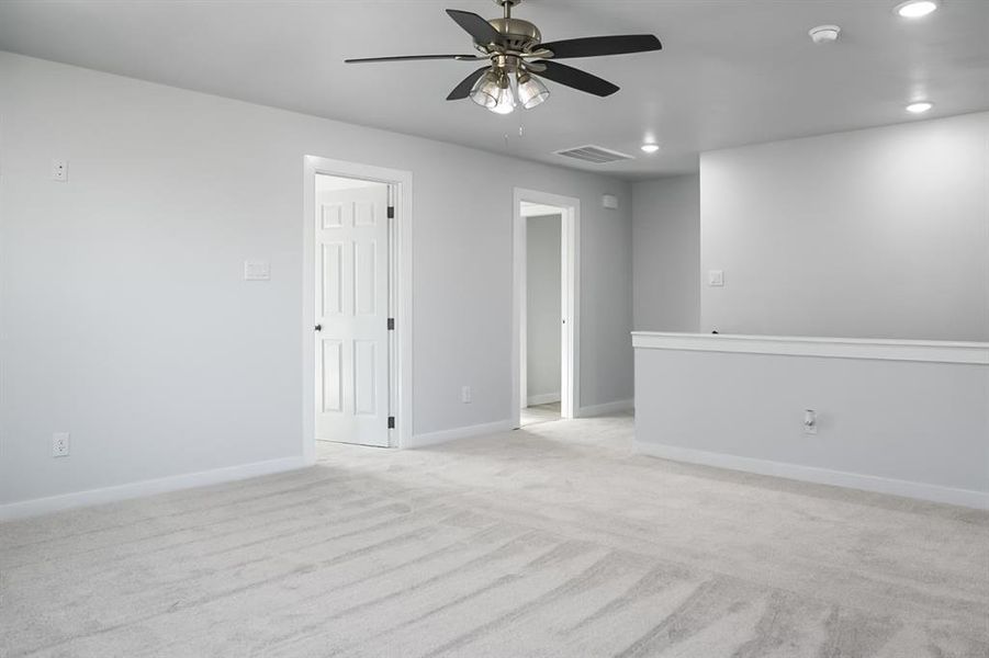 Spare room with light colored carpet and ceiling fan