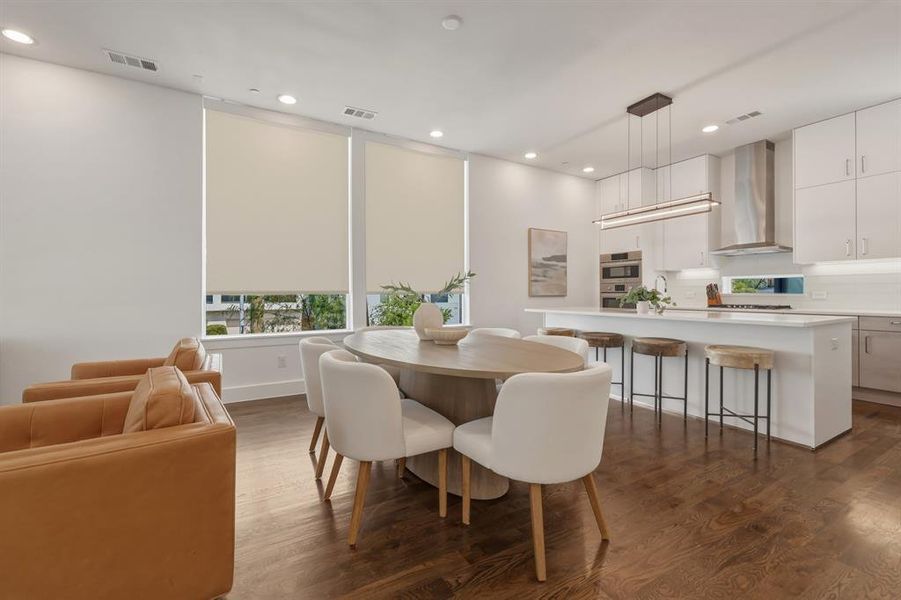 Dining area with dark wood-style flooring and recessed lighting