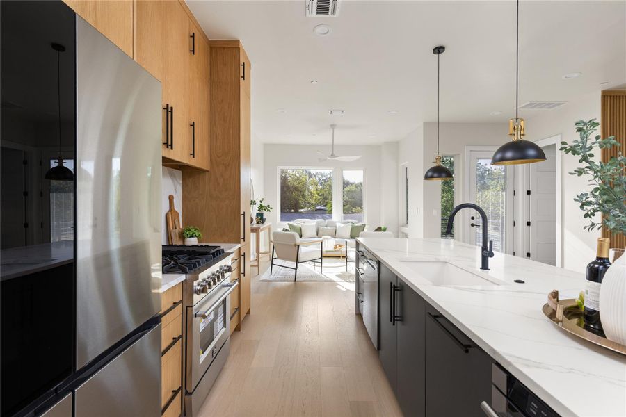 Gleaming hardwood floors and stone counters grace this open modern kitchen flow.